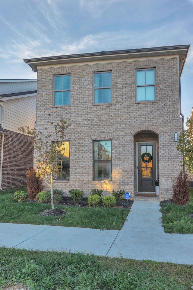 view of front facade featuring a front yard and brick siding