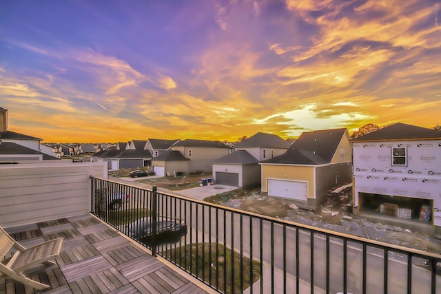 balcony at dusk featuring a residential view