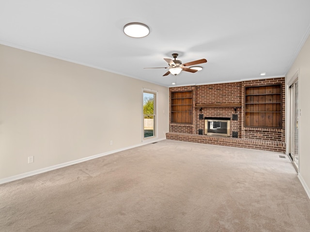 unfurnished living room featuring built in features, crown molding, a brick fireplace, light carpet, and baseboards