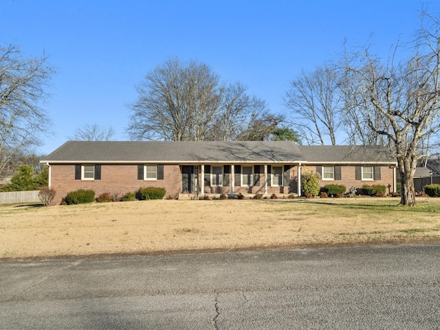 ranch-style home featuring a front yard and brick siding