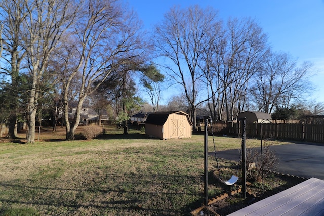 view of yard with an outbuilding, a shed, and fence