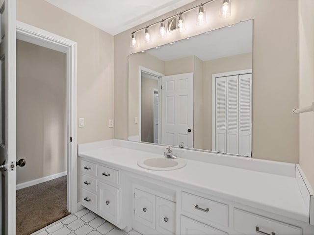 bathroom featuring a closet, vanity, baseboards, and tile patterned floors