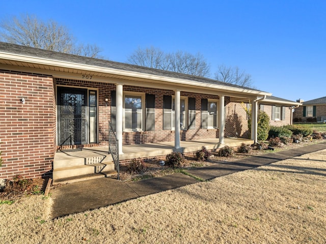 view of front of house featuring a porch and brick siding