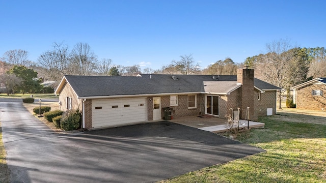 single story home featuring aphalt driveway, brick siding, a chimney, a garage, and a front lawn