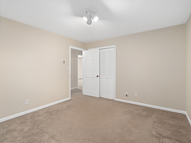 unfurnished bedroom featuring a closet, carpet, and baseboards