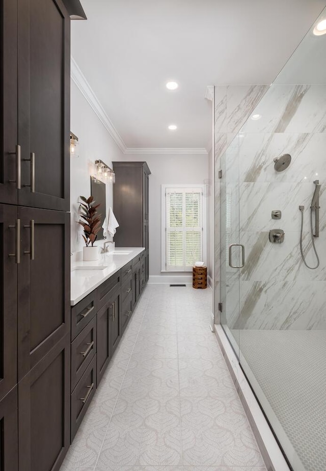 full bathroom featuring a marble finish shower, double vanity, recessed lighting, ornamental molding, and a sink