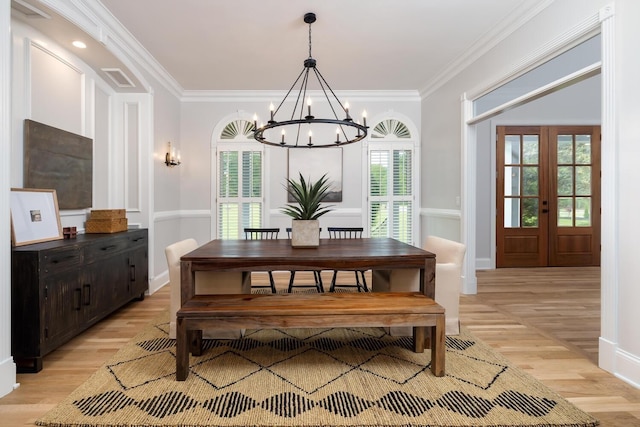 dining space featuring light wood finished floors, ornamental molding, a chandelier, and baseboards