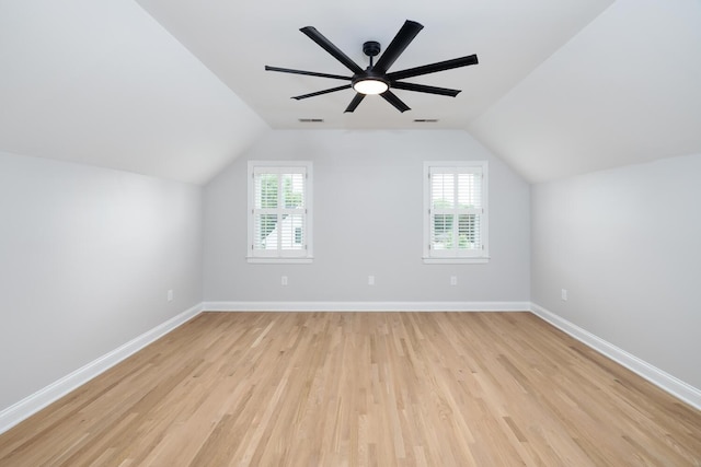 bonus room featuring vaulted ceiling, plenty of natural light, baseboards, and light wood-style floors