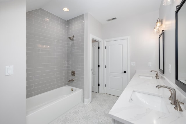 full bath featuring double vanity, bathtub / shower combination, a sink, and visible vents