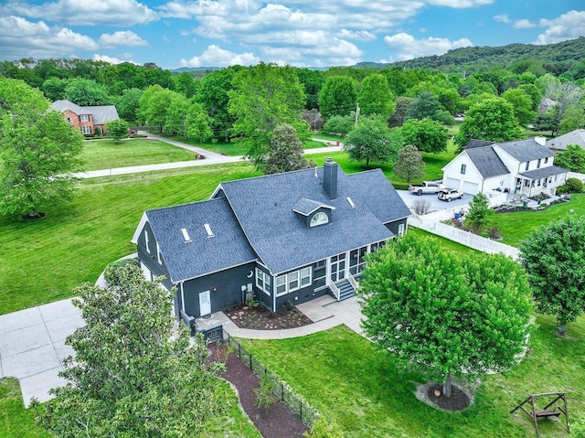 drone / aerial view featuring a wooded view and a residential view