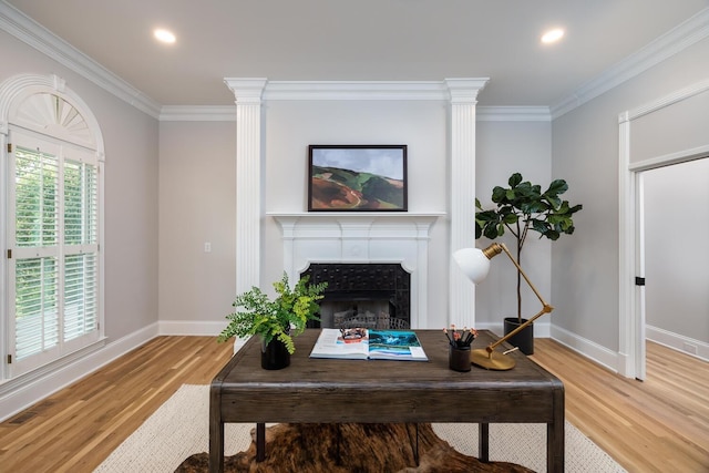 living room with a fireplace, baseboards, crown molding, and wood finished floors