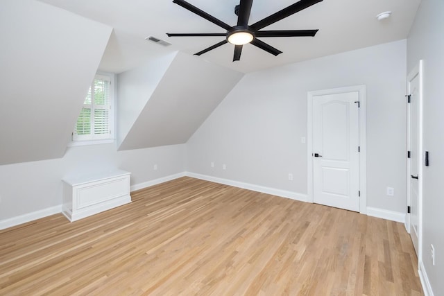 additional living space featuring ceiling fan, lofted ceiling, visible vents, baseboards, and light wood-type flooring