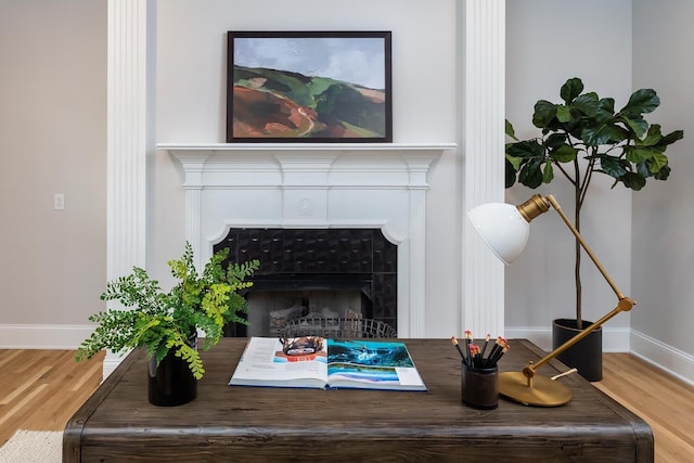 interior details featuring a fireplace, baseboards, and wood finished floors