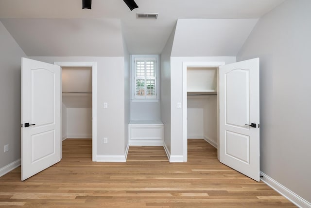 unfurnished bedroom with light wood finished floors, visible vents, a spacious closet, and baseboards