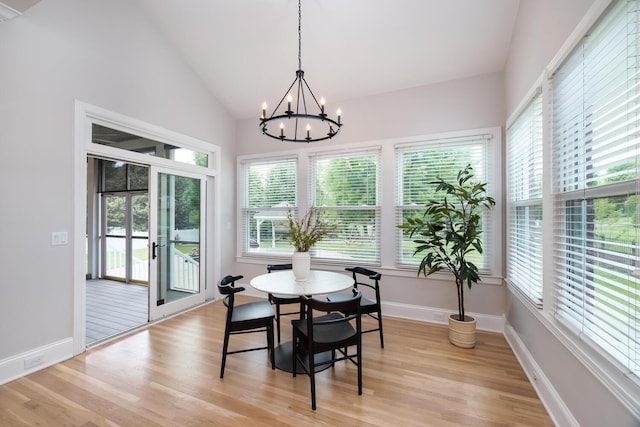 dining room with baseboards, high vaulted ceiling, an inviting chandelier, and light wood-style floors