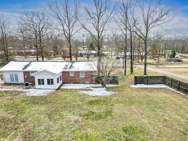 exterior space with a yard, brick siding, and fence