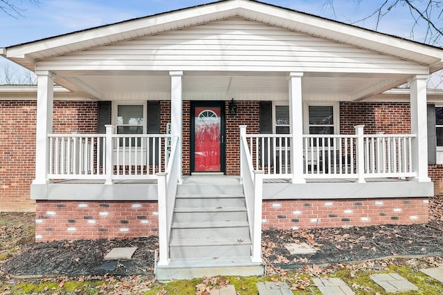view of front of house featuring covered porch and brick siding