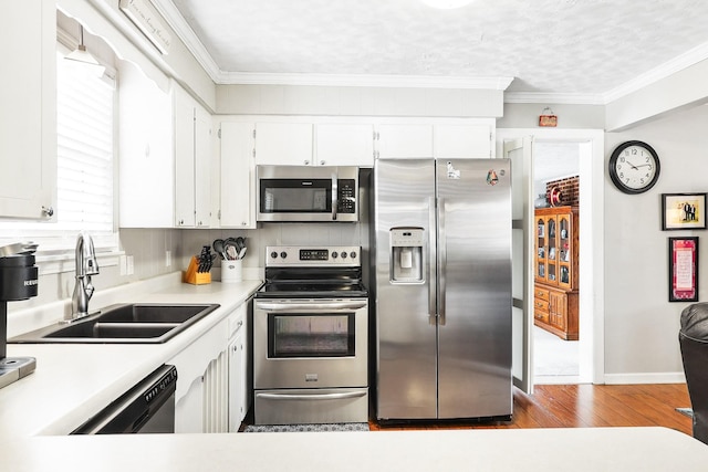 kitchen with white cabinets, appliances with stainless steel finishes, light countertops, and a sink