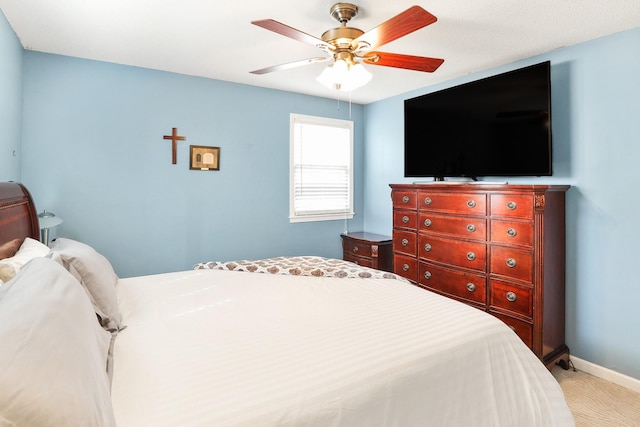 bedroom featuring light carpet, a ceiling fan, and baseboards