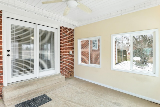 unfurnished sunroom featuring a ceiling fan