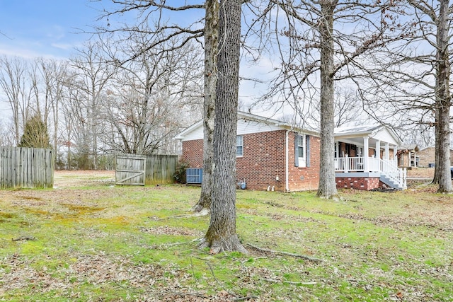 view of yard featuring a porch and fence