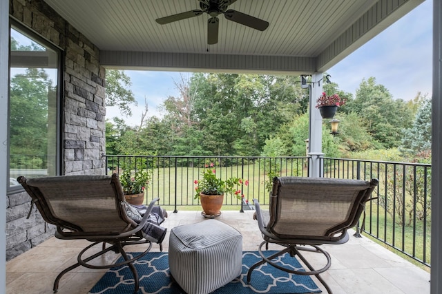 view of patio with a ceiling fan and a balcony