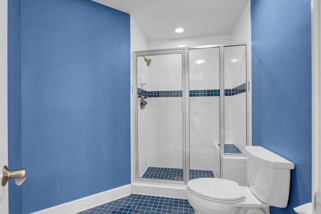 full bathroom featuring baseboards, a stall shower, toilet, and tile patterned floors