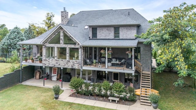 back of property featuring a yard, a chimney, stairway, a patio area, and stone siding