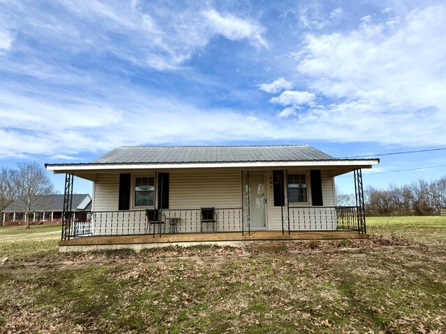 237 County Farm Rd, Ethridge, TN 38456 - view of front of home featuring covered porch, metal roof, and a front lawn