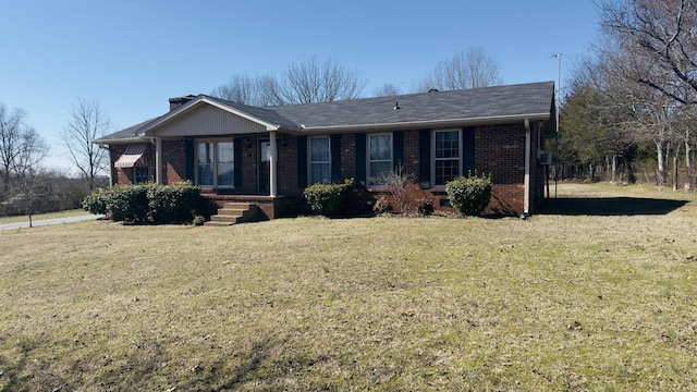 ranch-style home with a chimney, a front lawn, and brick siding