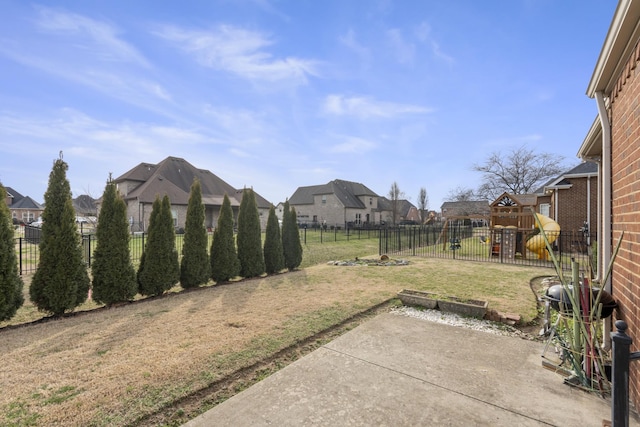 view of yard featuring a patio area, a fenced backyard, a residential view, and a playground