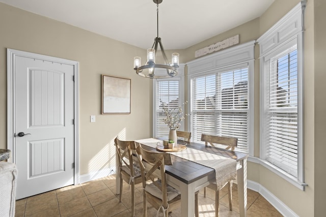 dining room featuring light tile patterned flooring, a notable chandelier, and baseboards