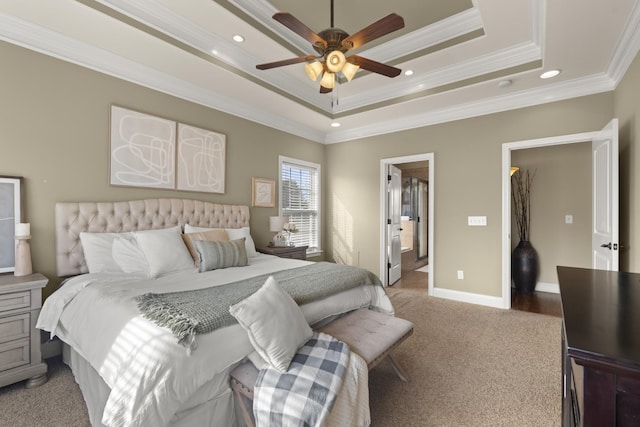 bedroom featuring baseboards, carpet floors, a tray ceiling, and crown molding