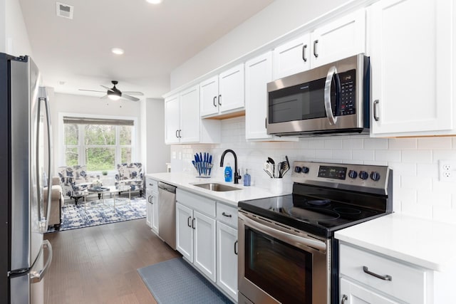 kitchen with visible vents, stainless steel appliances, light countertops, white cabinetry, and a sink