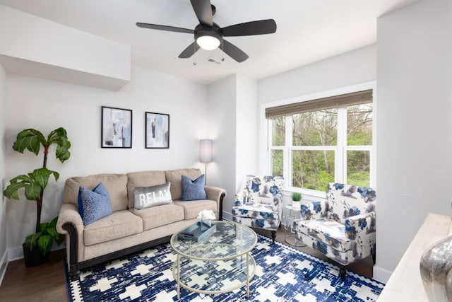 living area with visible vents, baseboards, ceiling fan, and wood finished floors