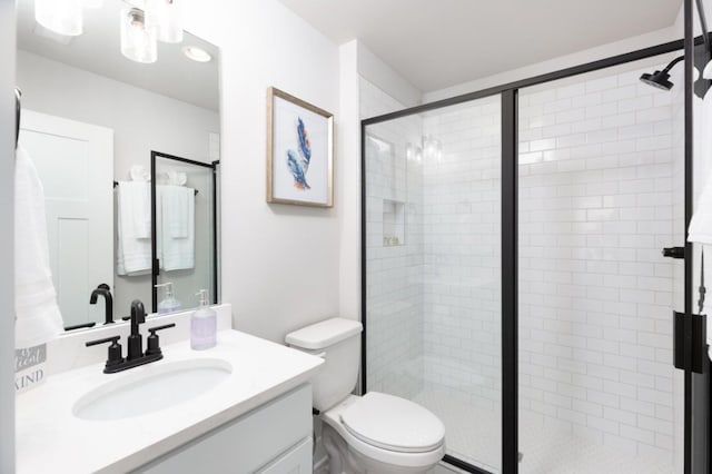 full bath featuring toilet, a shower stall, and vanity