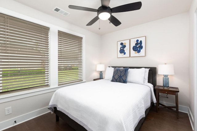 bedroom featuring baseboards, visible vents, ceiling fan, and dark wood-type flooring