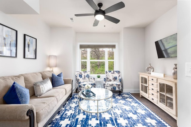 living area featuring ceiling fan, visible vents, and baseboards