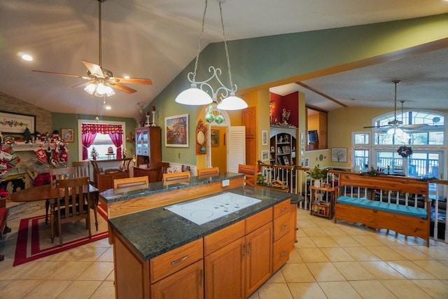 kitchen featuring light tile patterned floors, hanging light fixtures, lofted ceiling, and a center island