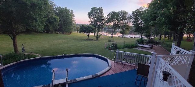 outdoor pool featuring a yard and a wooden deck