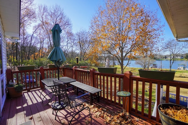 deck featuring outdoor dining space and a water view