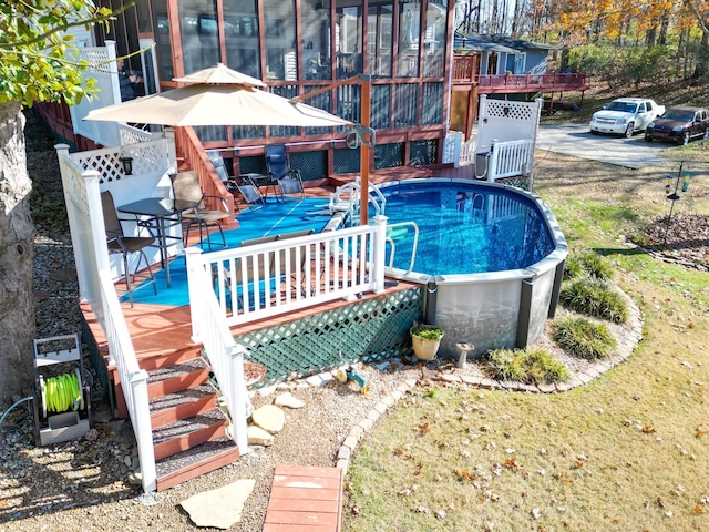 pool featuring a gazebo, a sunroom, and a wooden deck