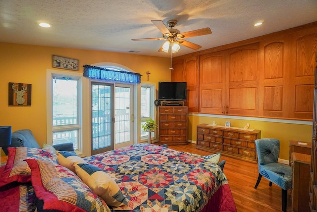 bedroom with ceiling fan, a textured ceiling, wood finished floors, and recessed lighting