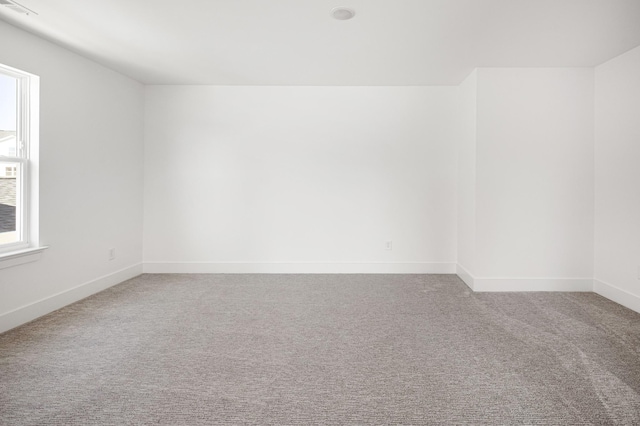 carpeted spare room featuring visible vents and baseboards