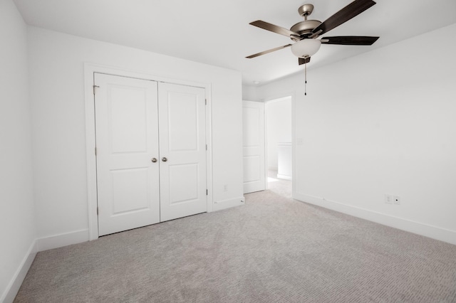 unfurnished bedroom featuring a closet, carpet flooring, a ceiling fan, and baseboards