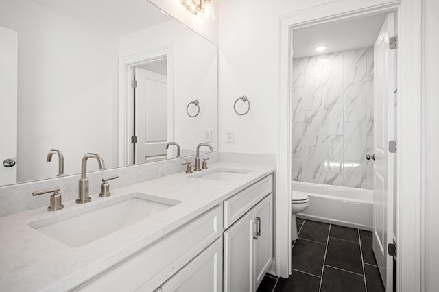 bathroom featuring tile patterned floors, a sink, toilet, and double vanity