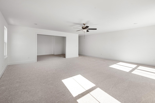 unfurnished bedroom with light carpet, baseboards, and a ceiling fan