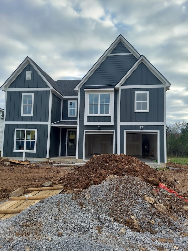 view of front facade with a garage, roof with shingles, and board and batten siding