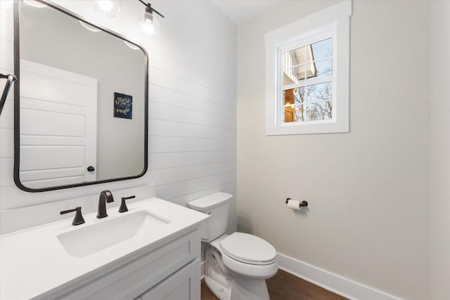 bathroom featuring wood finished floors, vanity, toilet, and baseboards