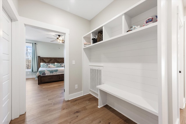 mudroom with a ceiling fan, wood finished floors, visible vents, and baseboards